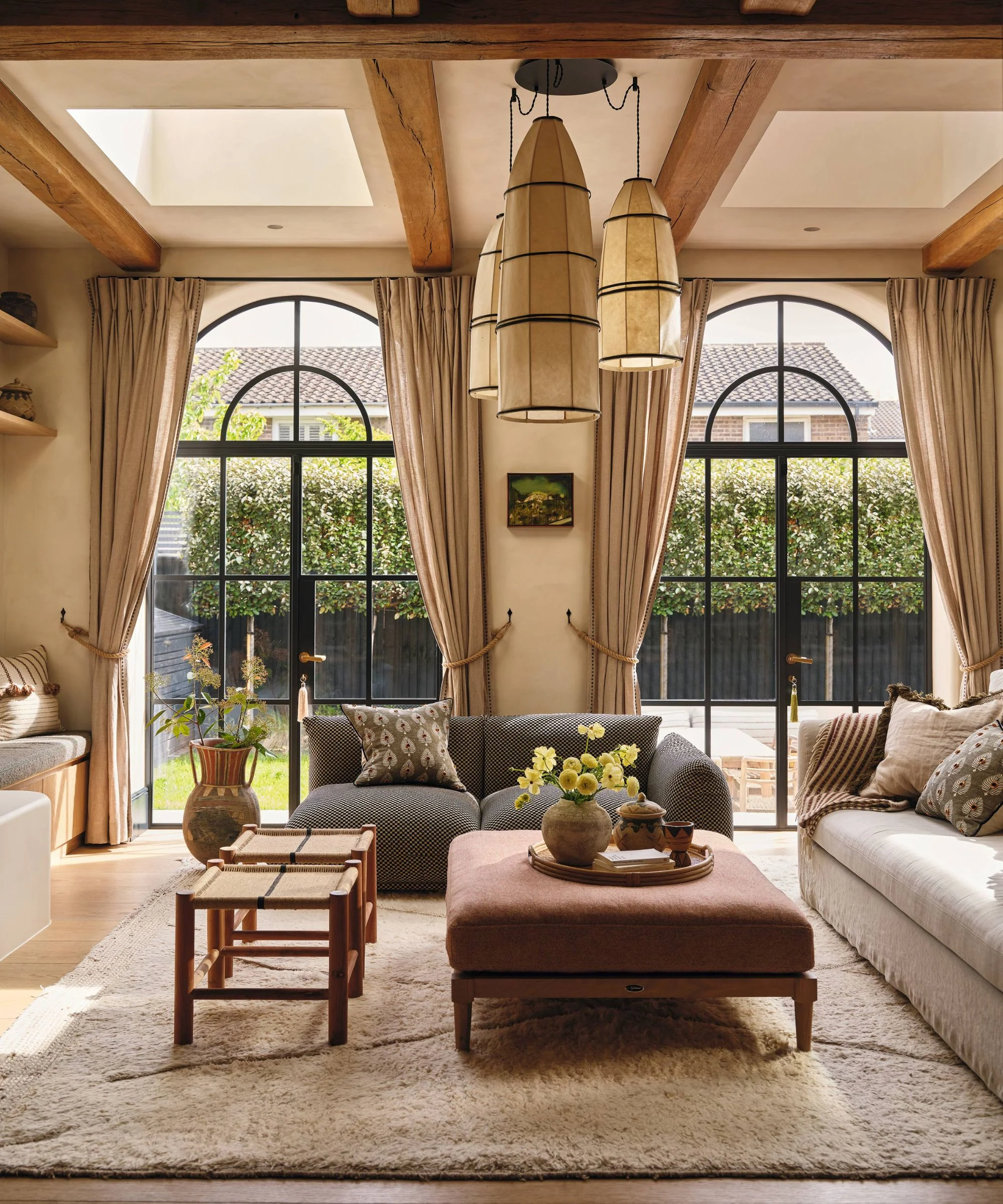 a refined european style living room with large arched crittal doors out to the patio